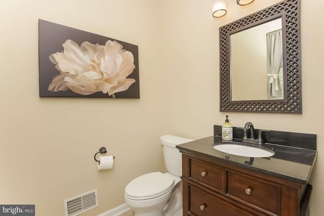 bathroom featuring toilet, visible vents, baseboards, and vanity