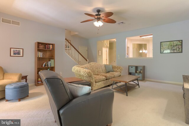 living room with light colored carpet, a ceiling fan, and baseboards