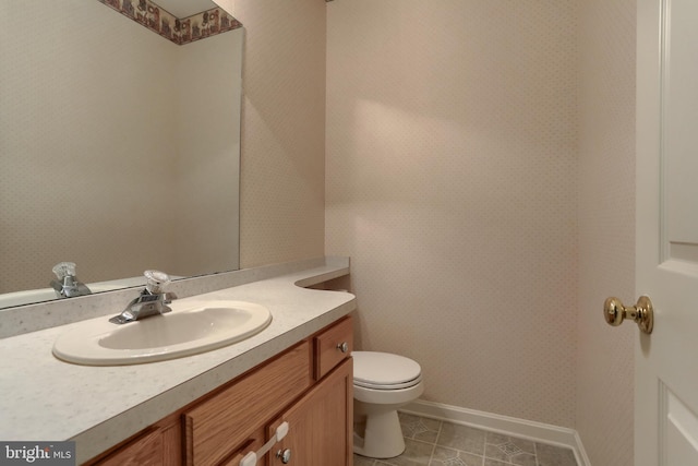 bathroom with vanity, tile patterned flooring, toilet, and baseboards