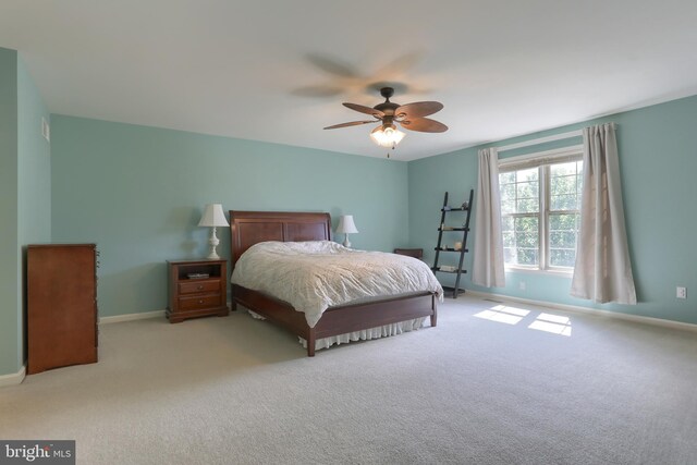 carpeted bedroom featuring baseboards and ceiling fan