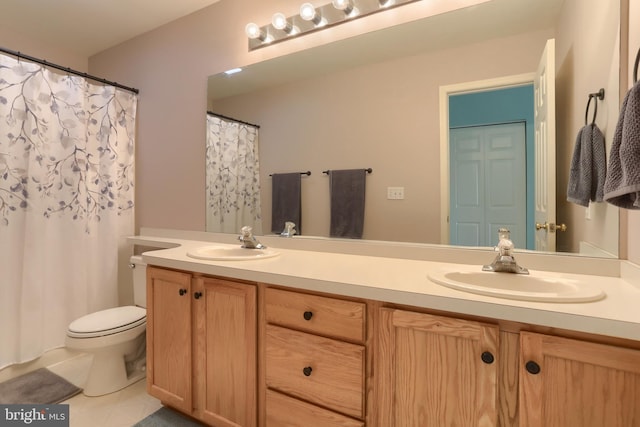bathroom featuring tile patterned floors, double vanity, and toilet
