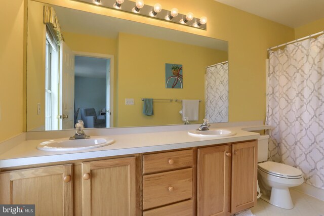 bathroom featuring double vanity, toilet, and tile patterned flooring