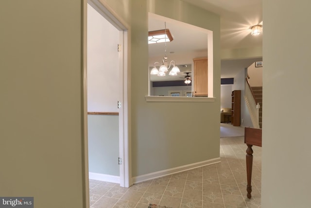hall with stairs, light tile patterned flooring, a chandelier, and baseboards
