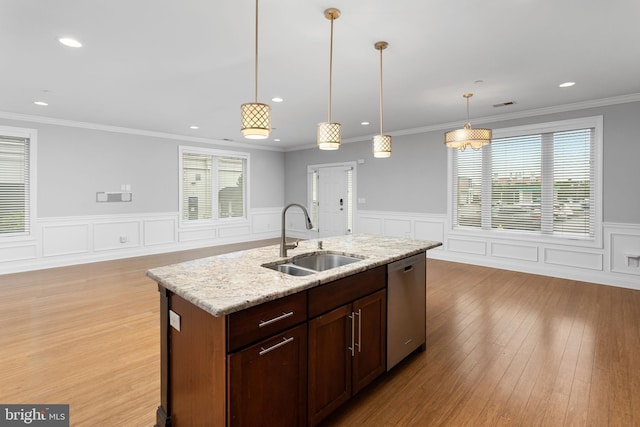 kitchen featuring a sink, dishwasher, light wood finished floors, wainscoting, and recessed lighting