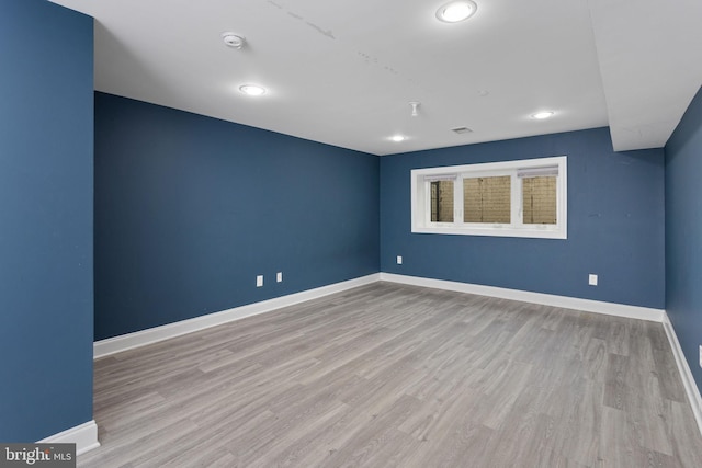 unfurnished room featuring wood finished floors, baseboards, a smoke detector, and recessed lighting