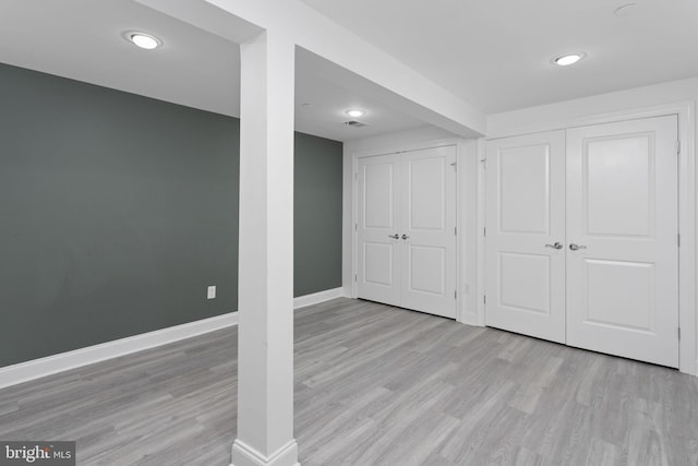 basement featuring baseboards, wood finished floors, and recessed lighting