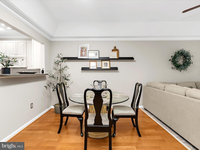 dining area with light wood finished floors, a ceiling fan, and baseboards