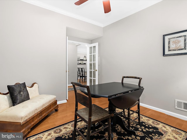 dining room featuring crown molding, baseboards, ceiling fan, and light wood-type flooring