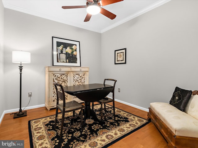dining space featuring ornamental molding, baseboards, wood finished floors, and a ceiling fan
