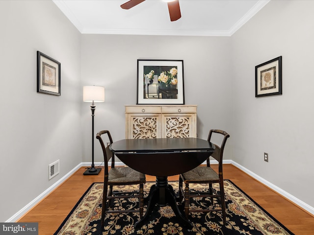 office featuring ceiling fan, baseboards, light wood-style flooring, and ornamental molding
