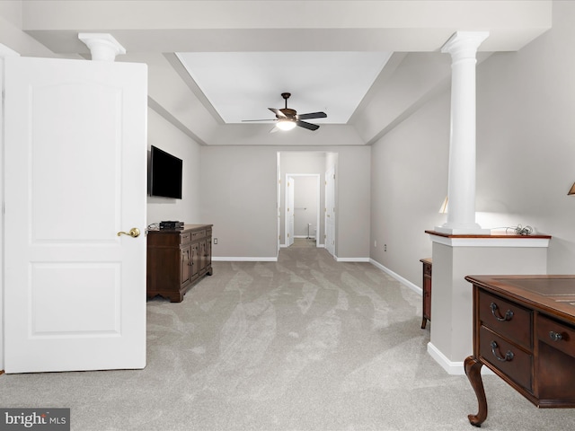unfurnished living room featuring light colored carpet, decorative columns, a ceiling fan, and baseboards