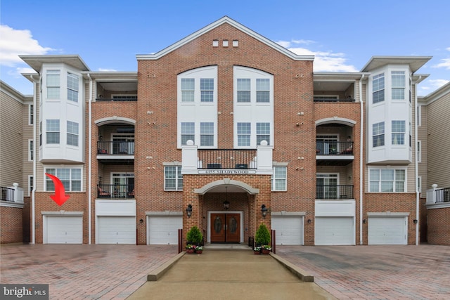 view of front of house featuring brick siding, an attached garage, driveway, and french doors