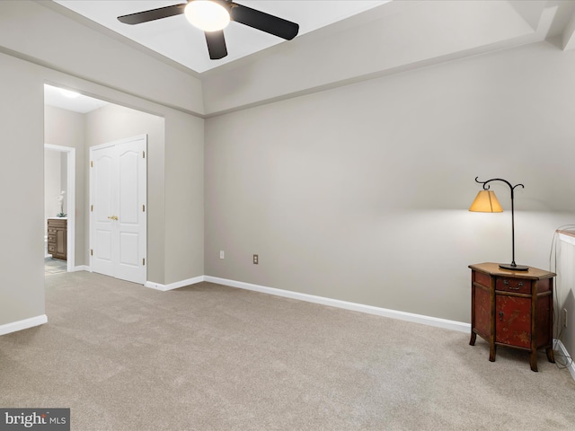 spare room with carpet floors, ceiling fan, and baseboards