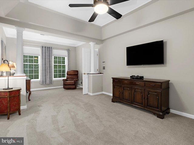 sitting room with ornate columns, light colored carpet, baseboards, and a ceiling fan
