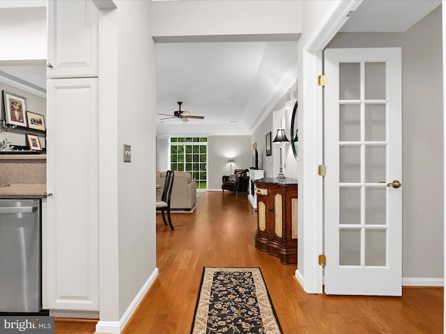corridor featuring light wood-type flooring, baseboards, and crown molding
