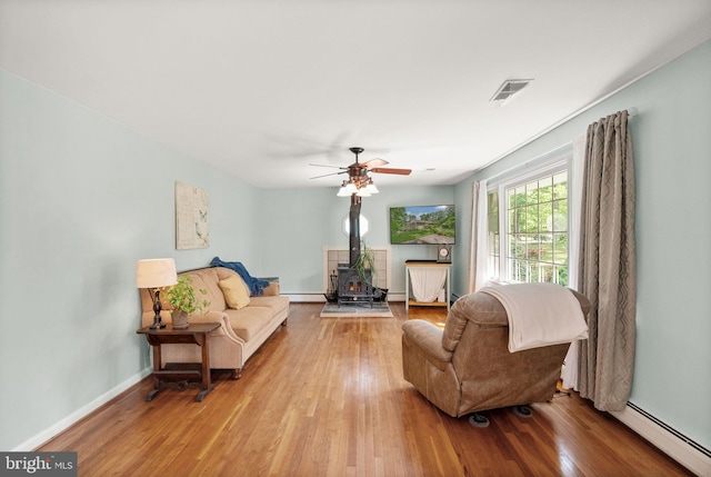 11080 Burwell Rd, Nokesville, VA 20181 - living area featuring a wood stove, a baseboard radiator, and wood finished floors