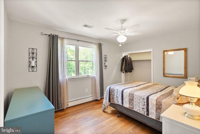 11080 Burwell Rd, Nokesville, VA 20181 - bedroom with a baseboard radiator, light wood-style floors, ceiling fan, a closet, and a walk in closet