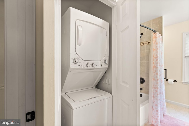 11080 Burwell Rd, Nokesville, VA 20181 - laundry area featuring stacked washer / dryer, light tile patterned floors, and baseboards