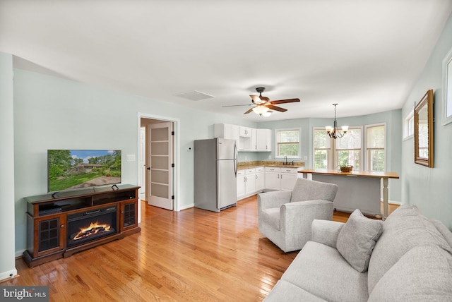 11080 Burwell Rd, Nokesville, VA 20181 - living area featuring light wood-style floors, ceiling fan, a chandelier, and baseboards