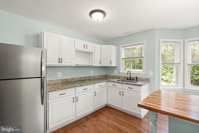 11080 Burwell Rd, Nokesville, VA 20181 - kitchen featuring freestanding refrigerator, a sink, wood finished floors, white cabinetry, and light stone countertops