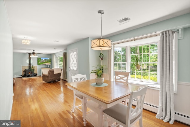 11080 Burwell Rd, Nokesville, VA 20181 - dining area with a wood stove, light wood-type flooring, and a baseboard heating unit
