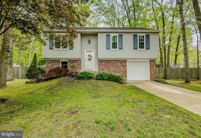 bi-level home with driveway, brick siding, and an attached garage