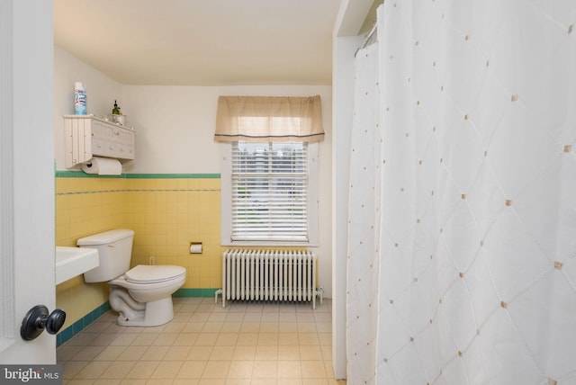 full bathroom with wainscoting, toilet, radiator, and tile walls