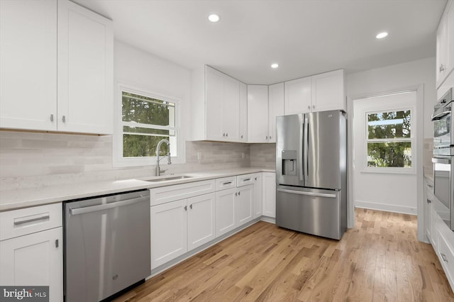 9828 Watts Branch Dr, Rockville, MD 20850 - kitchen with stainless steel appliances, a sink, light countertops, white cabinetry, and recessed lighting