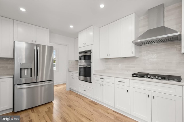 9828 Watts Branch Dr, Rockville, MD 20850 - kitchen with appliances with stainless steel finishes, wall chimney exhaust hood, light countertops, decorative backsplash, and white cabinetry