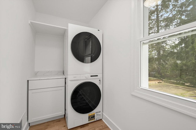 9828 Watts Branch Dr, Rockville, MD 20850 - washroom with stacked washer / dryer, light wood finished floors, and cabinet space