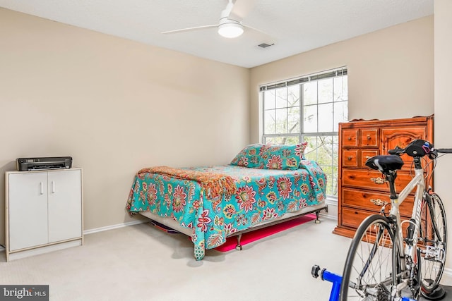 carpeted bedroom with ceiling fan and baseboards