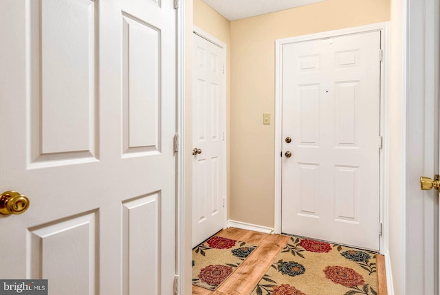 doorway featuring light wood-type flooring and baseboards