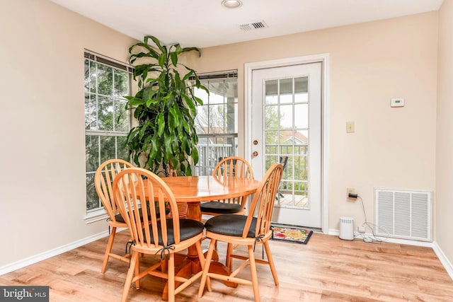 dining space with plenty of natural light, baseboards, and wood finished floors