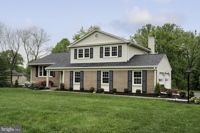 traditional-style house with a front yard, brick siding, and a garage