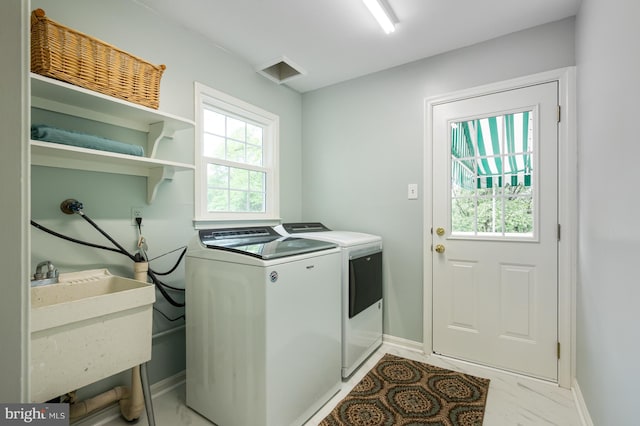 clothes washing area featuring washer and dryer, a sink, laundry area, baseboards, and marble finish floor