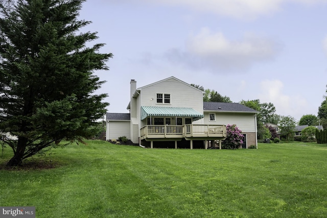 back of house featuring a yard, a chimney, and a wooden deck