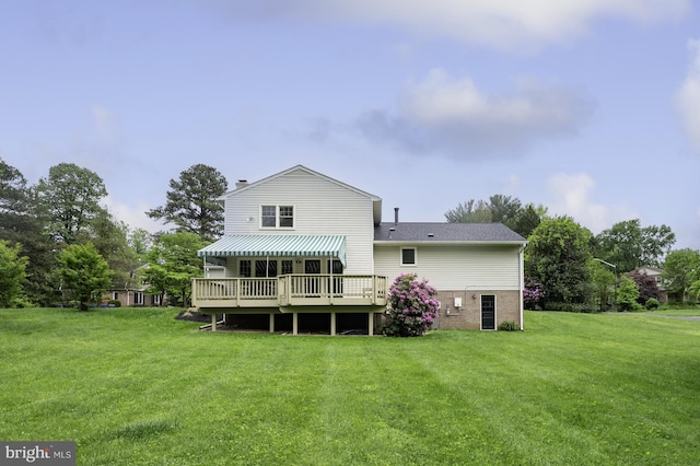 rear view of property with a yard, a chimney, and a wooden deck