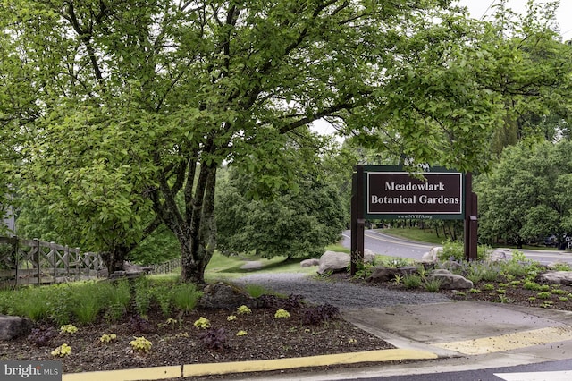 community / neighborhood sign featuring fence