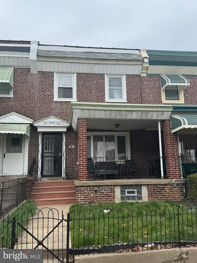 235 E Price St, Philadelphia, PA 19144 - townhome / multi-family property with a fenced front yard, entry steps, a porch, and brick siding