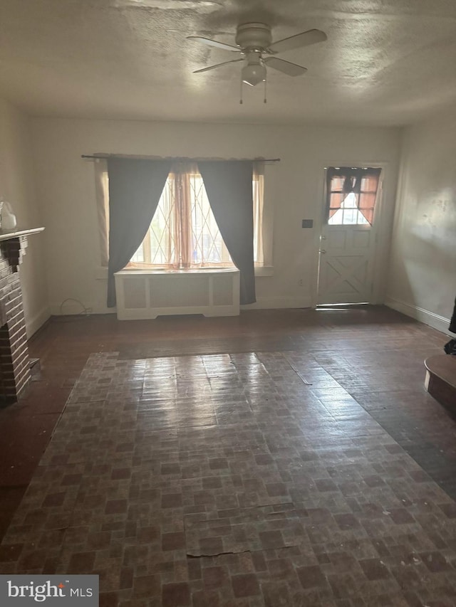 235 E Price St, Philadelphia, PA 19144 - unfurnished living room featuring a fireplace, ceiling fan, brick floor, and baseboards