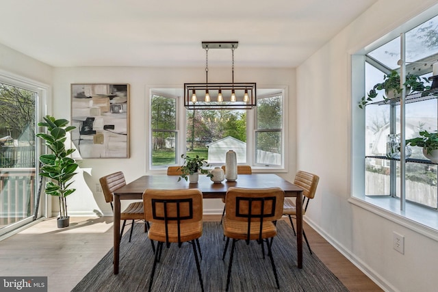 dining area with wood finished floors, baseboards, and a chandelier