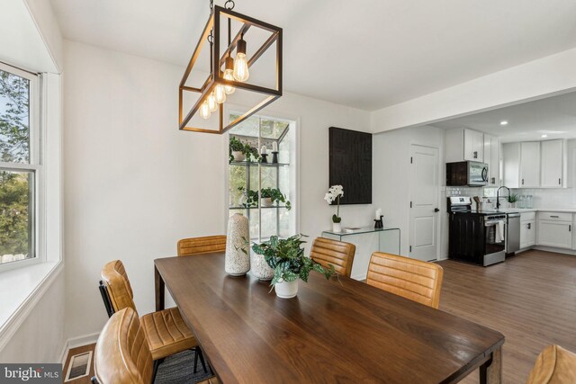 dining space with a chandelier, wood finished floors, and recessed lighting