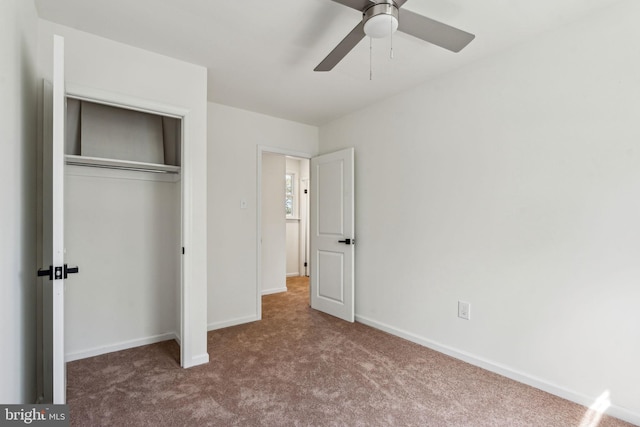 unfurnished bedroom featuring carpet floors, a closet, baseboards, and ceiling fan