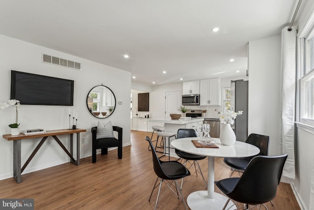 dining area featuring wood finished floors, recessed lighting, and baseboards