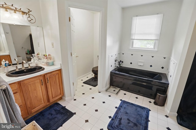 full bath featuring vanity, a garden tub, and tile patterned floors