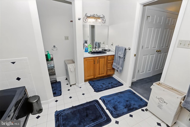 full bath featuring tile patterned flooring, vanity, and baseboards