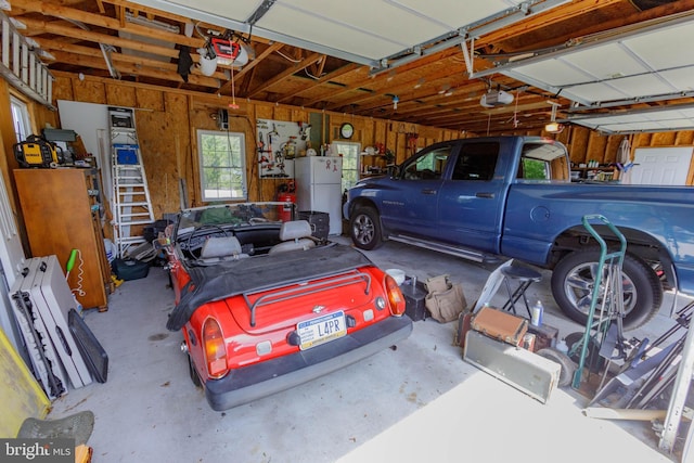 garage featuring freestanding refrigerator and a garage door opener
