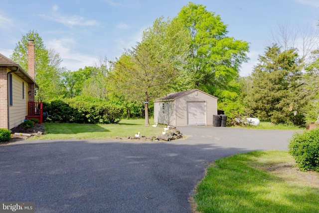 detached garage featuring driveway and a storage unit