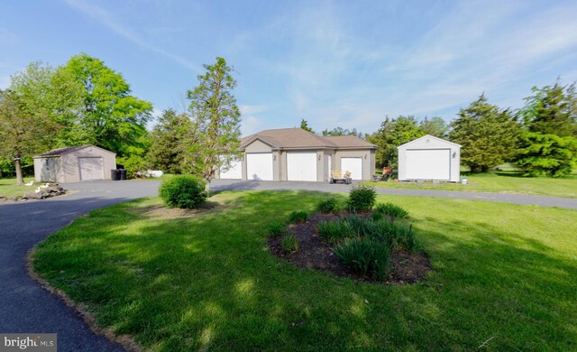 view of front of property with an outbuilding, a storage shed, and a front lawn