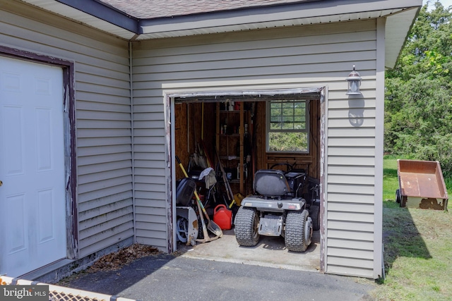 property entrance featuring roof with shingles and a garage